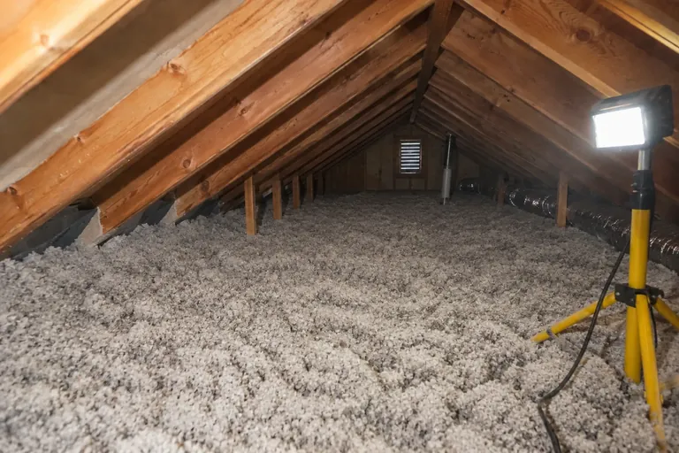 After: Full-depth blown insulation running right up to a baffle at the eave