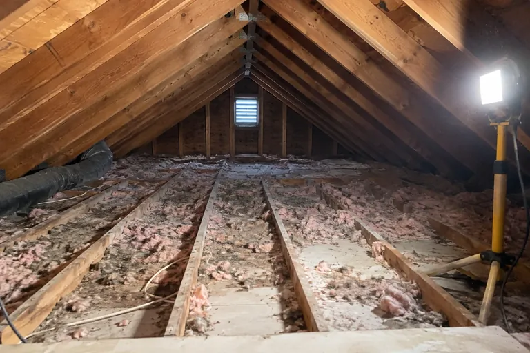 Before: A few inches of patchy old insulation with joist tops and drywall visible