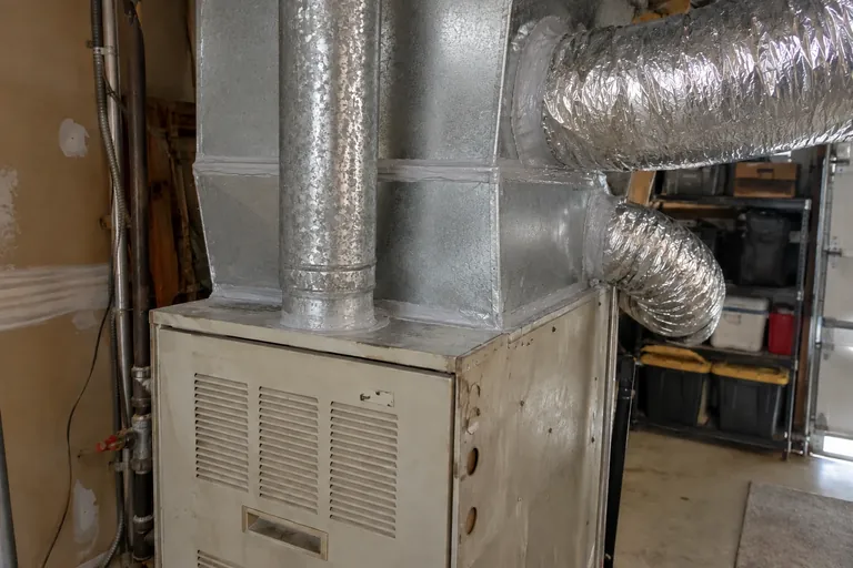 After: Clean plenum with mastic-sealed takeoffs and new insulated flex duct leading up into the attic